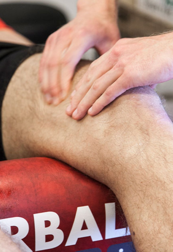 A runner massaging warm gel into a sore quad before a morning training session